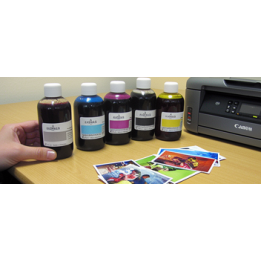 Encre colorée: six bouteilles d’encre arrière-plan et photos imprimées sur le bureau; le lot est destiné à cartouches Canon PGI5